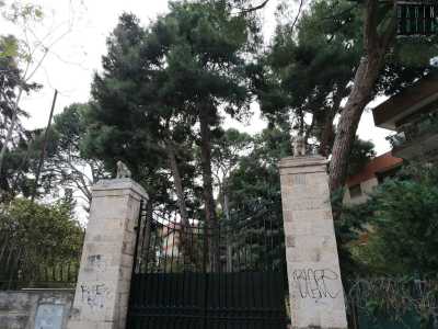 ...si staglia un maestoso cancello nero tra due colonne squadrate in pietra